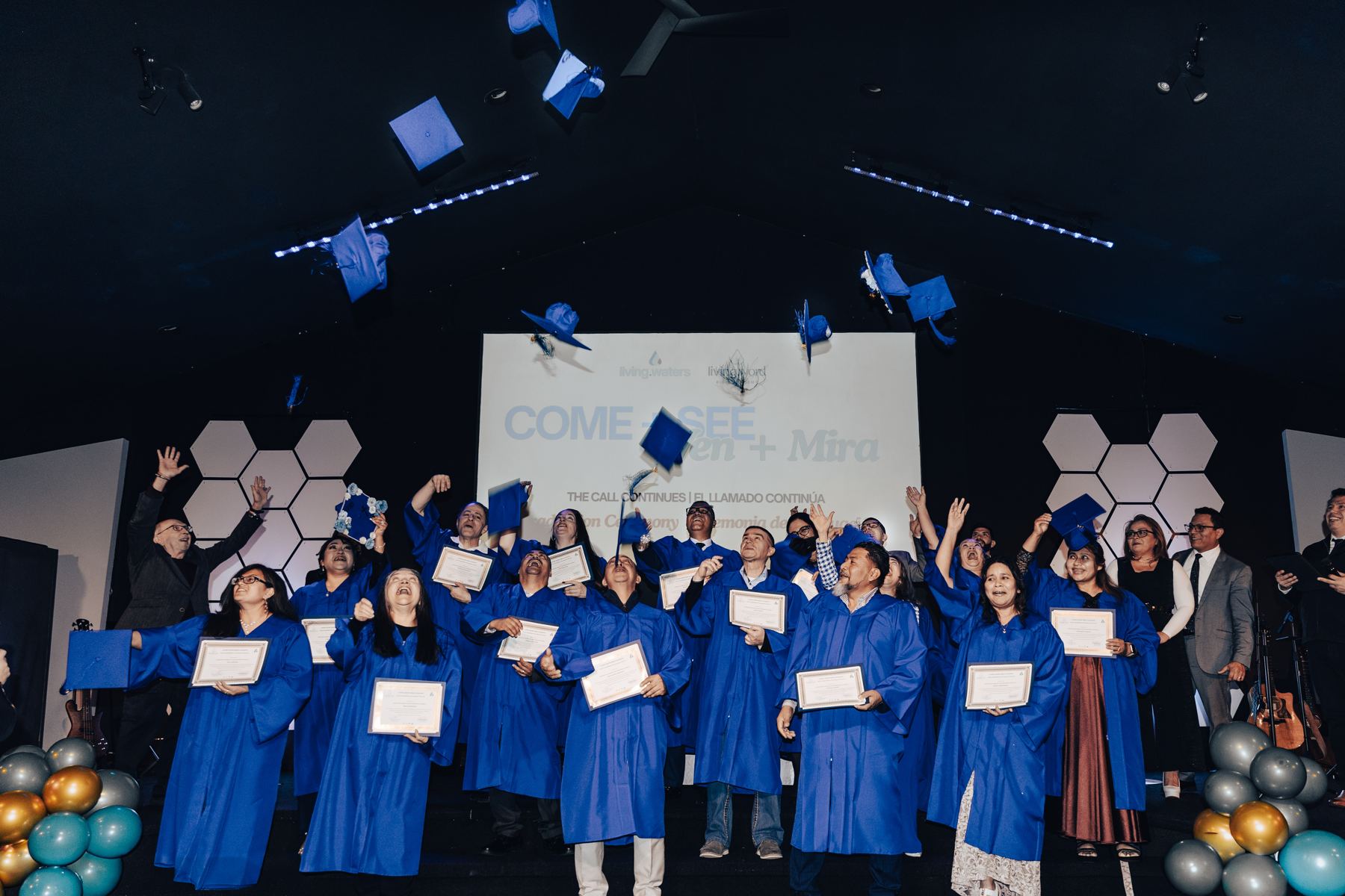Bible Academy graduates throwing their caps